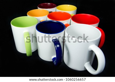 insulated unprinted cups for sublimation of different shapes, colors and designs designer on a black background isolated