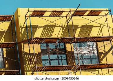 Insulation of the building facade with mineral wool. Fragment of the house sheathed with heat-saving material. Close-up - Shutterstock ID 2009450246