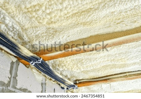Insulation of the ceiling in the house with polyurethane foam. Insulating foam between wooden beams