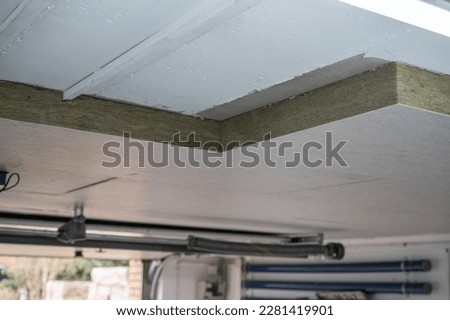 Insulation panels made of mineral wool, which were glued under a basement ceiling.
