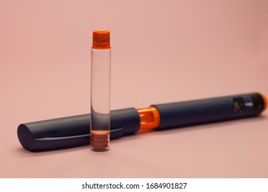 Insulin Cartridge And Injector Pen On A Pink Background