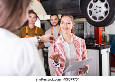 Insurance Agent Discussing With The Mechanics Renewal Of Car 