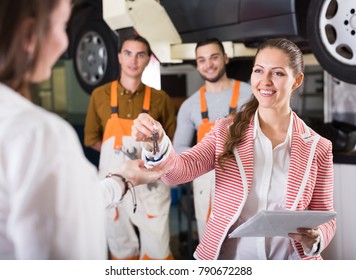 Insurance Agent Discussing With The Mechanics Renewal Of A Car 