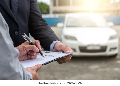 Insurance Agent examine Damaged Car and customer filing signature on Report Claim Form process after accident, Traffic Accident and insurance concept.