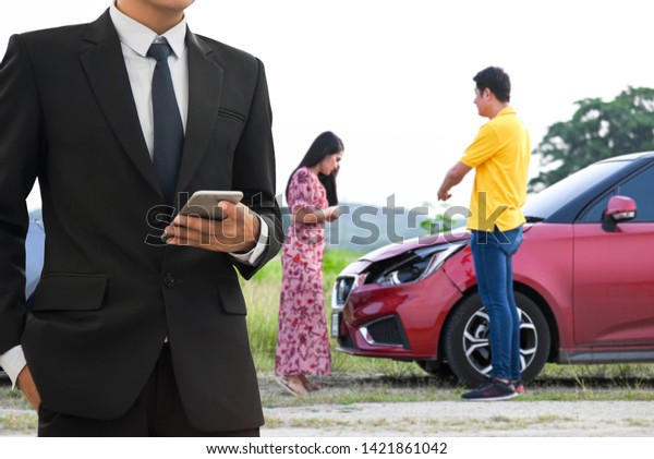Insurance Agent examine Damaged Car\
. Car insurance officers provide assistance to\
victims