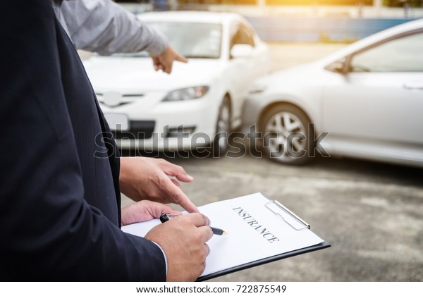 Insurance Agent examine Damaged Car and filing\
Report Claim Form after accident, Traffic Accident and insurance\
concept.