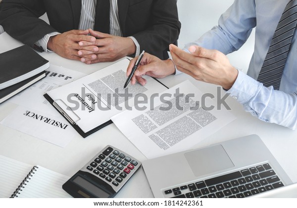 Insurance agent explaining insurance policy to\
customer in office\
room.