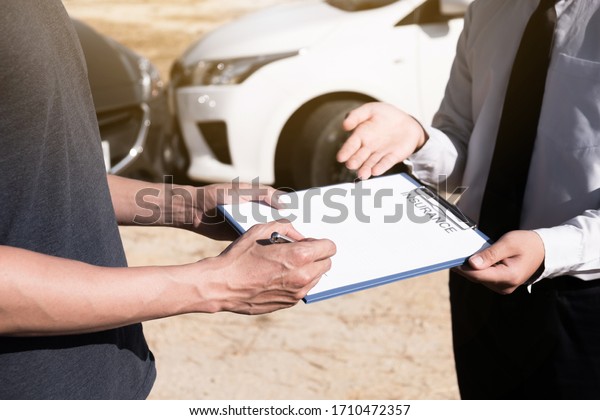 Insurance agent giving the\
car owner is sign the agreement for accident claim, Car insurance\
concept.