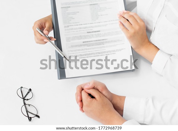 Insurance agent holding\
pen, the policyholder and explain insurance policy to customer.\
life insurance\
concept.