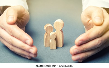 Insurance agent holds hands near the family. The concept of insurance of family life and property. Family care and helping hand concept. Health insurance. Health care. Security and Property Protection - Shutterstock ID 1305873580