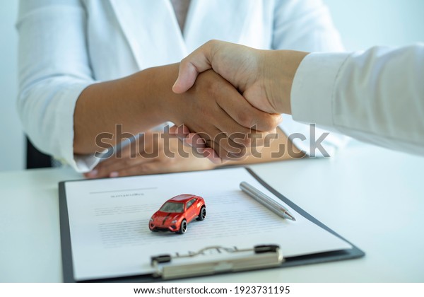 Insurance agent\
joins hands with the insured after proposing the concept of car\
insurance. And contract insurance concept agreement Making rental\
and purchase agreements for\
cars