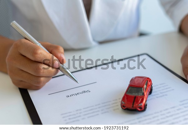 The\
insurance agent is letting the insured sign the contract. After the\
concept of car insurance. And contract insurance concept agreement\
Making rental and purchase agreements for\
cars