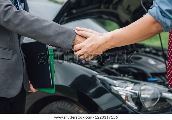 Insurance agent working claim process in payment\
on from parties. Insurance agent examine damaged car and customer\
checking on report claim form after accident, Accident and\
insurance claim\
concept.
