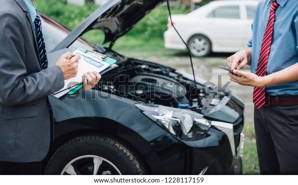 Insurance agent working claim process in payment\
on from parties. Insurance agent examine damaged car and customer\
checking on report claim form after accident, Accident and\
insurance claim\
concept.