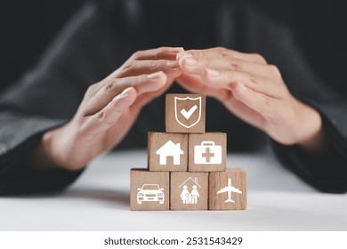 Insurance and assurance concept, Businesswoman protect wooden blocks with insurance icons for medical, life, car, home, travel insurance. - Powered by Shutterstock