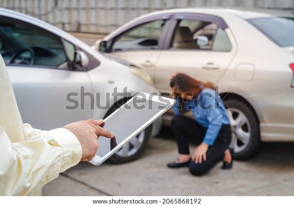 insurance company employee Saving insurance claim\
information on the tablet. The woman was sad that the car was hit.\
car insurance concept
