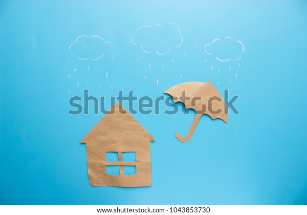Insurance concept of house insurance. house\
under umbrella