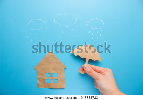 Insurance concept of house insurance. house\
under umbrella