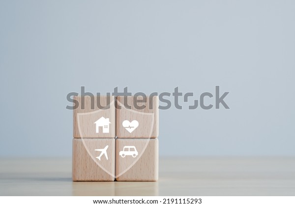 Insurance concept. Protection against a possible\
eventuality. House, Car, travel and Health icon on wooden block for\
assurance life\
concept.