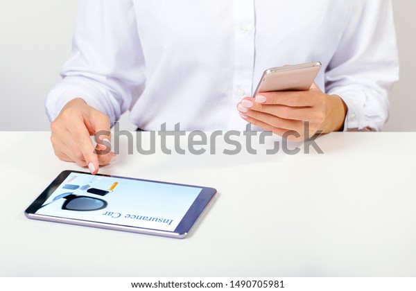 Insurance concept. Women use digital tablet and\
smart phone to search for insurance online. Car insurance website\
in a digital tablet\
screen.