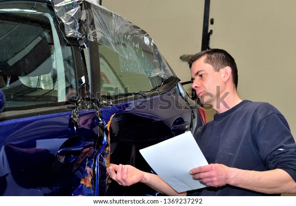 Insurance expert working
at damaged car.