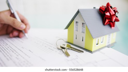 insurance of fire and theft .the hands of an insurer or real estate agent showing a house with floor plan and documents with ensured house keys.concept of home protection, family, insurance.rent house