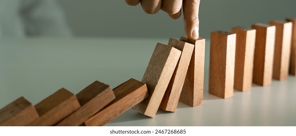 insurance with hands protect domino. Businessman hands stop dominoes falling in house crisis. business risk control and planning and strategies to run prevent insurance businesses.