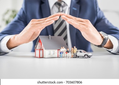 Insurance house, car and family health live concept. The insurance agent presents the toys that symbolize the coverage. - Shutterstock ID 703607806
