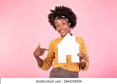 Insurance, Loan, Real Estate And Family Concept. Smiling Black Woman Buying Home, Holding Paper House In Hands And Smiling, Paying Debt, Standing White Background Happy