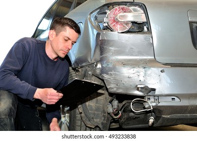 Insurance Mechanic At Work In Car Body Shop.