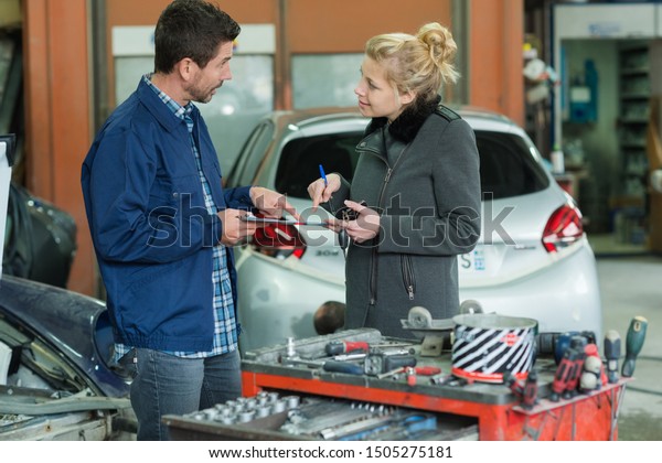 insurance mechanic at\
work in car body shop