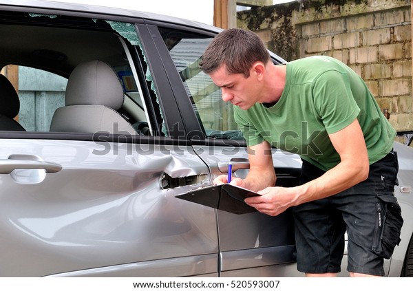 insurance mechanic at\
work in car body\
shop.