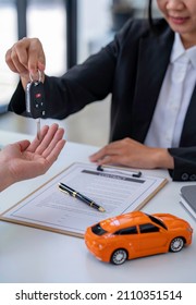 Insurance Officers Hand Over The Car Keys After The Tenant. Have Signed An Auto Insurance Document Or A Lease Or Agreement Document Buying Or Selling A New Or Used Car With A Car