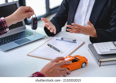 Insurance officers hand over the car keys after the tenant. have signed an auto insurance document or a lease or agreement document Buying or selling a new or used car with a car - Shutterstock ID 2110352015
