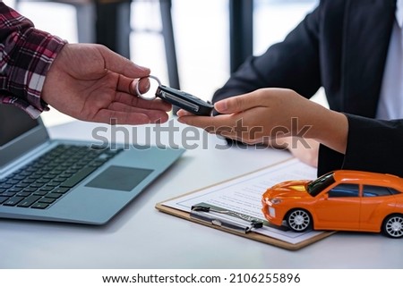 Insurance officers hand over the car keys after the tenant. have signed an auto insurance document or a lease or agreement document Buying or selling a new or used car with a car
