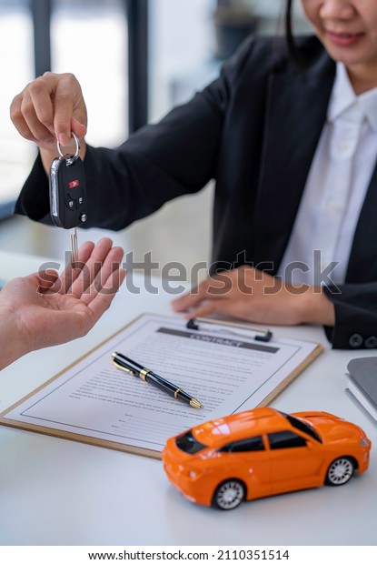 Insurance officers\
hand over the car keys after the tenant. have signed an auto\
insurance document or a lease or agreement document Buying or\
selling a new or used car with a\
car