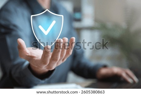 Insurance plan support. Insure medicare contract. Protect financial management. A man is holding a hand up to a screen with a blue shield on it. The shield has a checkmark on it.
