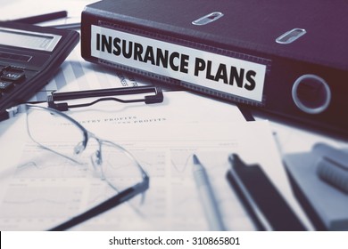 Insurance Plans - Ring Binder On Office Desktop With Office Supplies. Business Concept On Blurred Background. Toned Illustration.