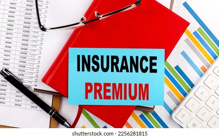 INSURANCE PREMIUM text on a sticky on red notebook on chart background - Shutterstock ID 2256281815
