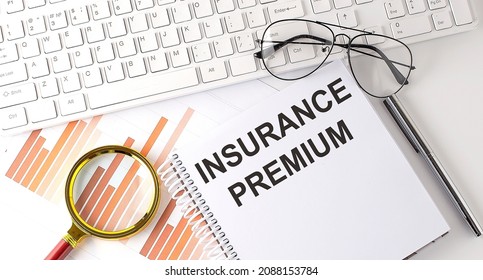 INSURANCE PREMIUM text written on notebook with keyboard, chart,and glasses - Shutterstock ID 2088153784