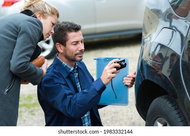 Insurance Representative Taking Picture Of Car Dent