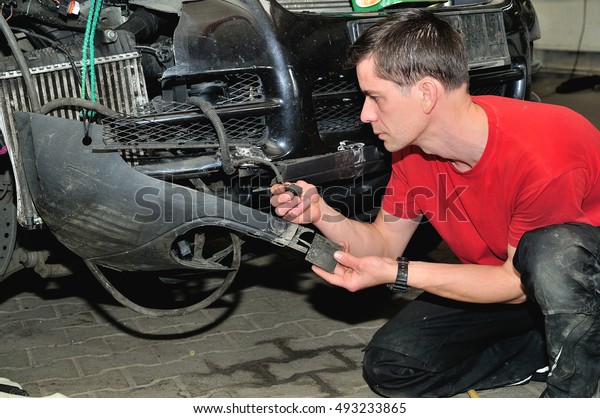 Insurance worker inspecting\
car damage.