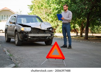 Insurer inspects car and calculates damage after car accident. Man Auto Insurance Agent Inspect vehicle damage condition. Broken car on road with Red triangle warning Stop sign