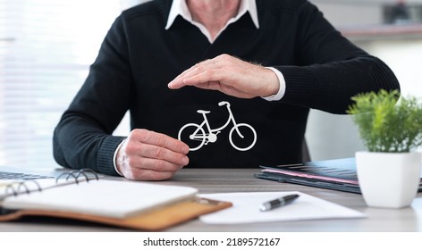 Insurer protecting a bicycle with his hand - Shutterstock ID 2189572167