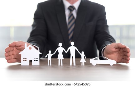 Insurer protecting house, family and car with his hands - Shutterstock ID 642545395