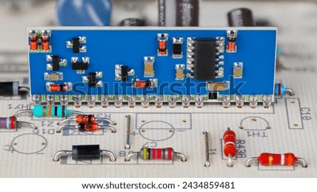 Integrated circuit and surface mounted electronic components on a blue PCB. Close-up a hybrid module in white printed wiring board with through-hole technology in part of gas burner automatic control.