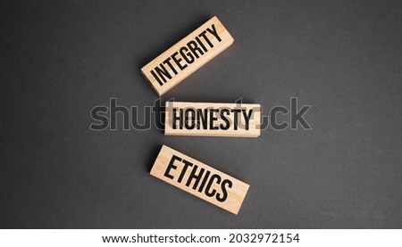 INTEGRITY, HONESTY, ETHICS words on wooden blocks on yellow background. Business ethics concept.