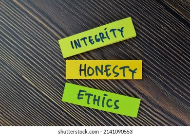 Integrity, Honesty, Ethics write on sticky notes isolated on Wooden Table. Selective focus on integrity, honesty, ethics text