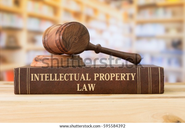 Intellectual Property law books and a\
gavel on desk in the library. concept of legal\
education.