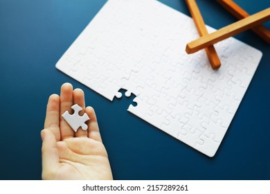 Intellectual puzzles. The puzzle empty. The hand puts together puzzle pieces. Brain training. - Shutterstock ID 2157289261